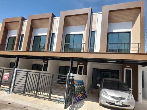 Modern residential townhouses with balconies and parking spaces