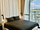 Modern bedroom with floor-to-ceiling windows and city view