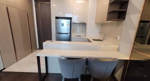 Modern apartment kitchen with integrated appliances and breakfast bar