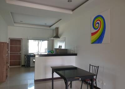 Modern kitchen with dining area featuring an open layout and colorful artwork