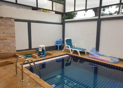 Indoor swimming pool with lounging chairs and play items