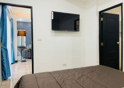 Modern bedroom with flat-screen TV and adjoining room view