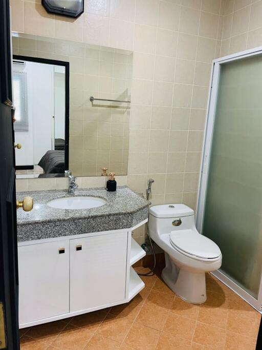 Modern small bathroom with granite countertop and glass shower door