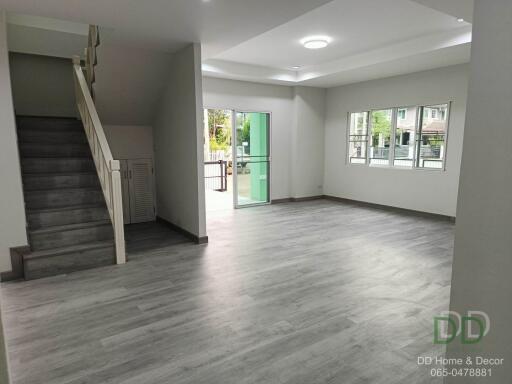 Spacious modern living room with staircase and ample natural light