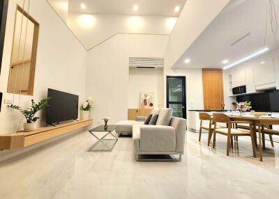 Spacious open plan living room and kitchen with modern furnishings and ample lighting