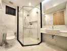 Modern bathroom with marble finish and glass shower enclosure