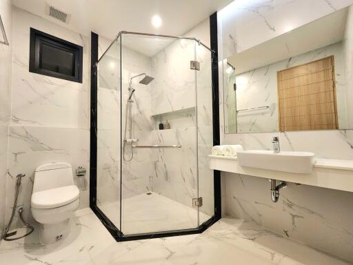 Modern bathroom with marble finish and glass shower enclosure