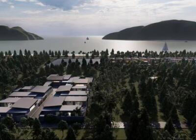 Aerial view of coastal residential property with multiple buildings surrounded by trees and ocean view