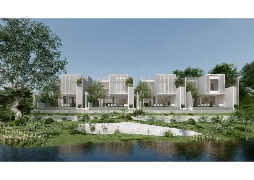 Modern residential buildings by a tranquil water body surrounded by lush greenery