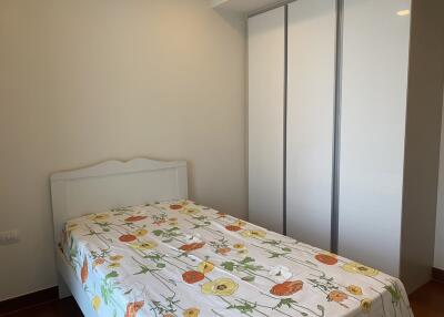 Well-lit bedroom with white decor and floral bedding