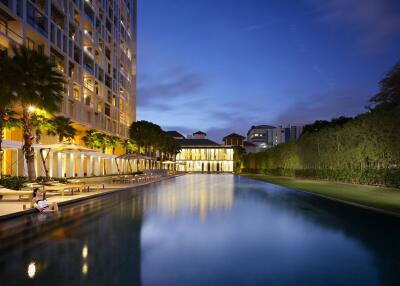 Luxurious Residential Building with Illuminated Pool at Twilight