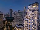 Evening cityscape showing modern high-rise buildings with illuminated windows