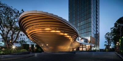 Modern architectural building with unique curved design and illuminated facade at twilight