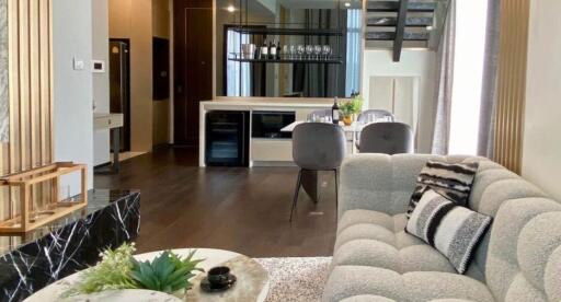 Spacious living room with modern furnishings, open layout to kitchen and dining area