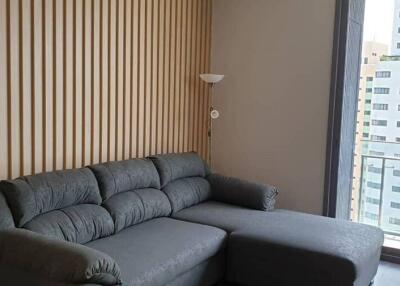 Modern living room with gray sectional sofa and patterned wall