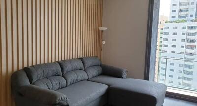 Modern living room with gray sectional sofa and patterned wall