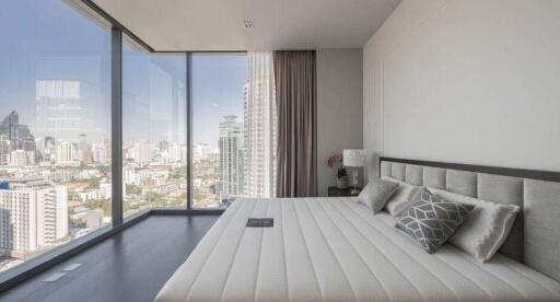 Modern bedroom with large windows and city view