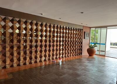Spacious and stylish lobby area with decorative wooden partition and modern furnishings