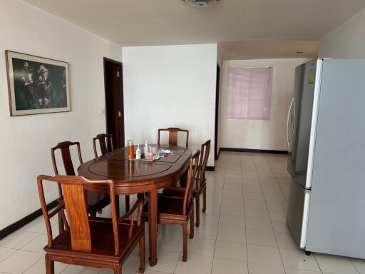 Spacious dining room with wooden furniture and adjacent kitchen