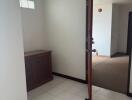 Spacious hallway with white tile flooring and natural light