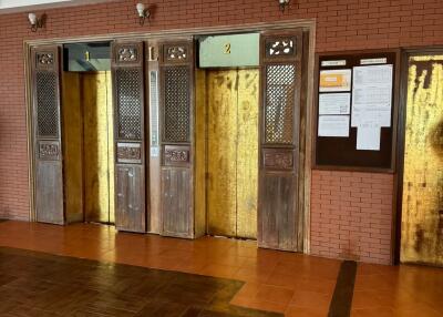 Vintage elevator lobby with wooden and metal doors and tiled flooring