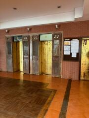 Vintage elevator lobby with wooden and metal doors and tiled flooring