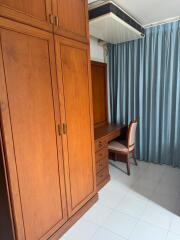 Spacious bedroom with large wooden wardrobe and study desk