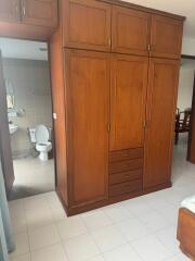 Bedroom with large wooden wardrobe and visible bathroom