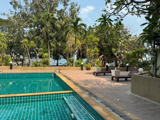 Luxurious outdoor pool with adjacent seating and lush greenery