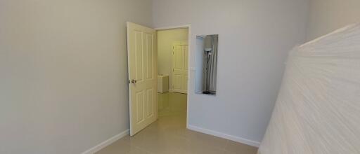 Unfurnished bedroom with open door leading to a hallway