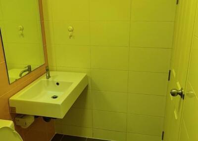 Compact bathroom with yellow wall tiles and dark floor tiles