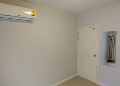 Minimalist bedroom with air conditioning unit and a mirror