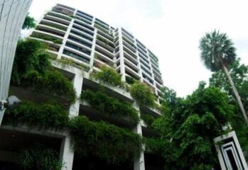 Modern residential building exterior with lush greenery