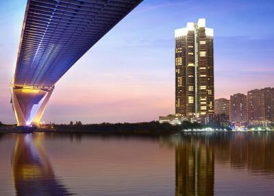 Modern city skyline with illuminated bridge and high-rise buildings at dusk