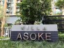 Front signage of Villa Asoke with green landscaping