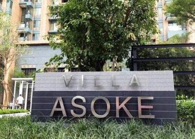 Front signage of Villa Asoke with green landscaping