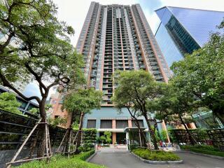 Exterior view of modern residential high-rise building with lush green landscaping