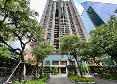 Exterior view of modern residential high-rise building with lush green landscaping
