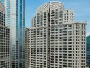 High-rise residential building surrounded by greenery and modern skyscrapers