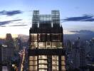 Modern high-rise building exterior at twilight with illuminated interiors and cityscape background