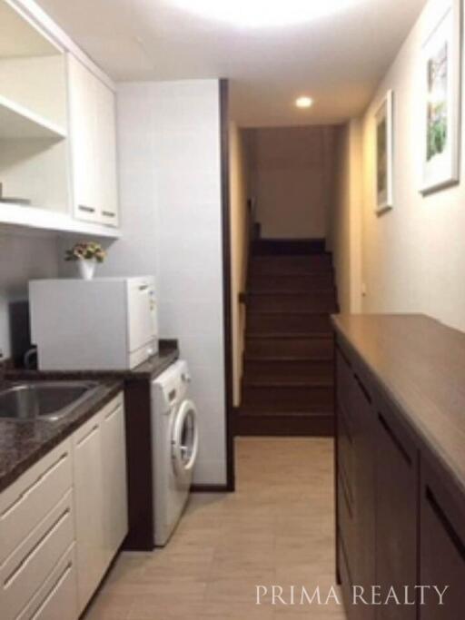 Modern kitchen with washing machine and wooden cabinets