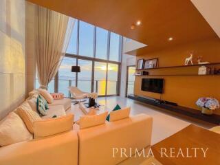 Spacious living room with floor-to-ceiling windows and ocean view