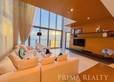 Spacious living room with floor-to-ceiling windows and ocean view