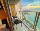 Ocean view balcony with seating area during sunset