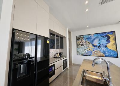 Modern kitchen with integrated appliances and living area view