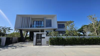 Modern two-story residential building with large windows and a unique architectural design