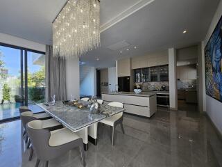 Spacious dining room with adjacent modern kitchen and garden view