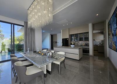 Spacious dining room with adjacent modern kitchen and garden view
