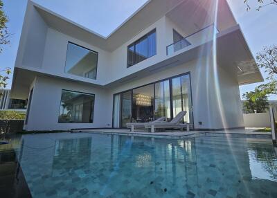 Modern two-story house with large windows and a swimming pool