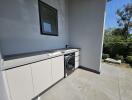 Modern outdoor laundry area with washer and ample cabinet space